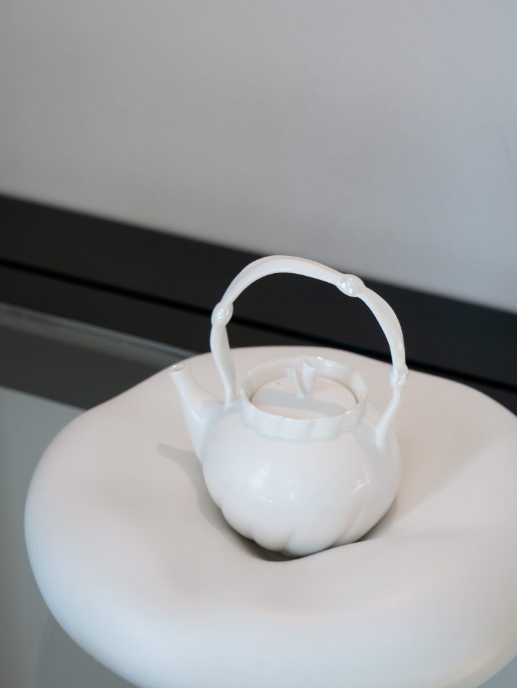 Hana Ikushima, “Teapot IV”, 2025, Porcelain clay, crystalline glaze, pearl luster, W10.0 x D12.0 x H15.0 cm / Hana Ikushima, “Pillow”, 2025, Porcelain, crystalline glaze, W21.0 x D21.0 x H7.0 cm © Hana Ikushima.